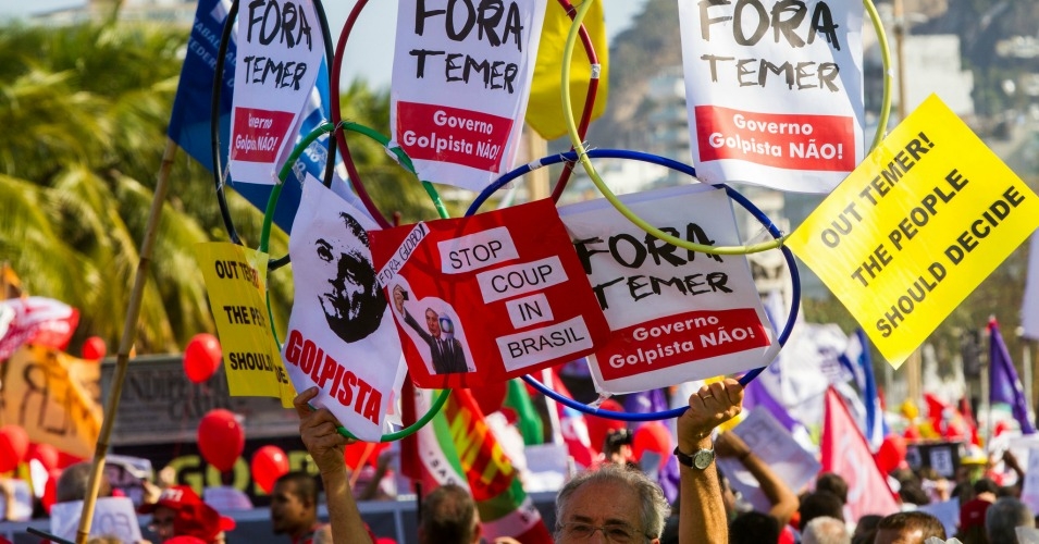 Demostrators hold signs during a march in Rio on August 5, 2016 . (Photo: Mídia NINJA/flickr/cc)