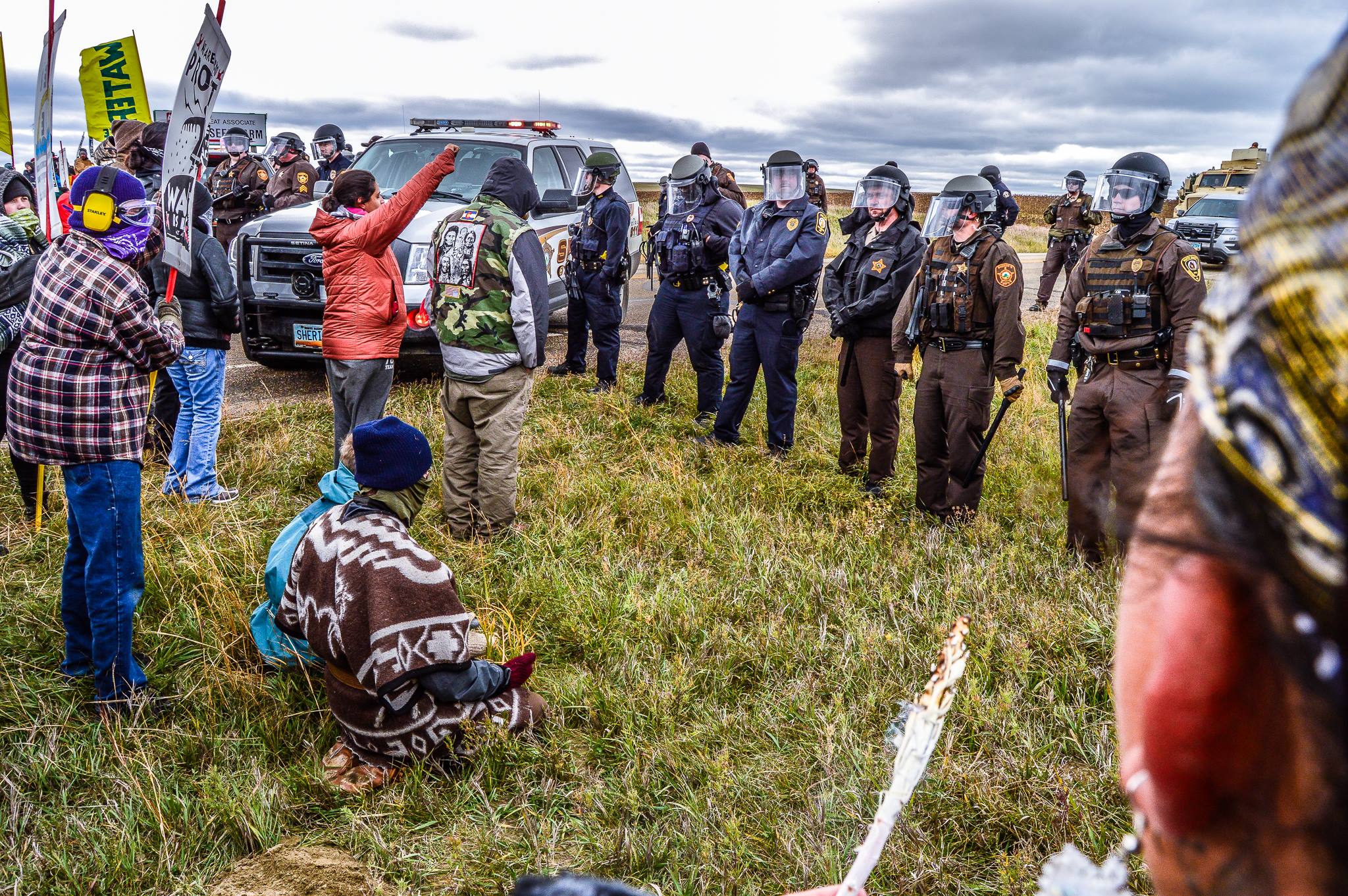 Water Protectors with prayer and burning sage at a roadblock with riot police and military style armored vehicles outside St Anthony, ND on Oct 5 2016. Photo: Sacred Stone Camp/Facebook